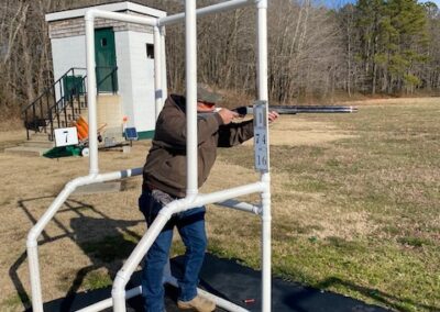 man with rifle shooting at gun range