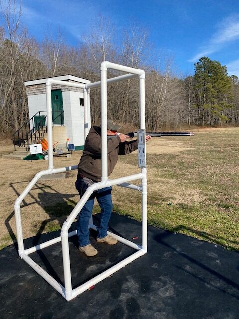 man with rifle shooting at gun range